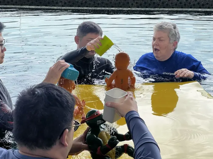 Trainees practising infant CPR technique in the pool