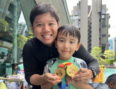 Coach and young swimmer showing off competition medals at a condo swim carnival